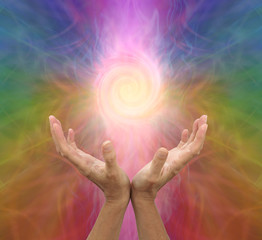 Poster - Channeling rainbow coloured  vortex healing energy  - female hands held open and palms upwards with a spiraling energy formation above on a multicoloured background and copy space