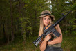 © Andzo Janovich - Young woman in boonie hat posing with gun in body camouflage and black leather shorts. Military style