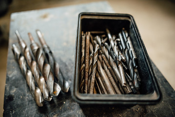 set of steel milling cutters for milling cutters in a rectangular box on the old black table, building old drills, work tools