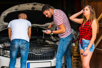 Frustrated friends trying to repair their car