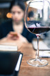 © filiz - young adult woman busy with her phone behind of a wine glass