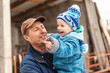 © dusanpetkovic1 - Close up of smiling granddad holding his grandson on the cold weather. Both dressed in warm winter clothes. Winter holidays on countryside concept.