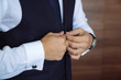 © romannoru - Close-up businessman groom wearing his jacket. Concept of men stylish elegance clothes