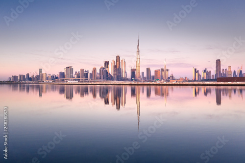 Photo Beautiful colorful sunrise lighting up the skyline and the reflection of Dubai Downtown