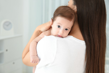 Wall Mural - Woman holding her baby at home, closeup