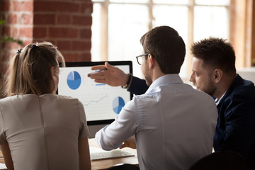 Canvas Print - Rear view at business analysts employees talking discussing work results