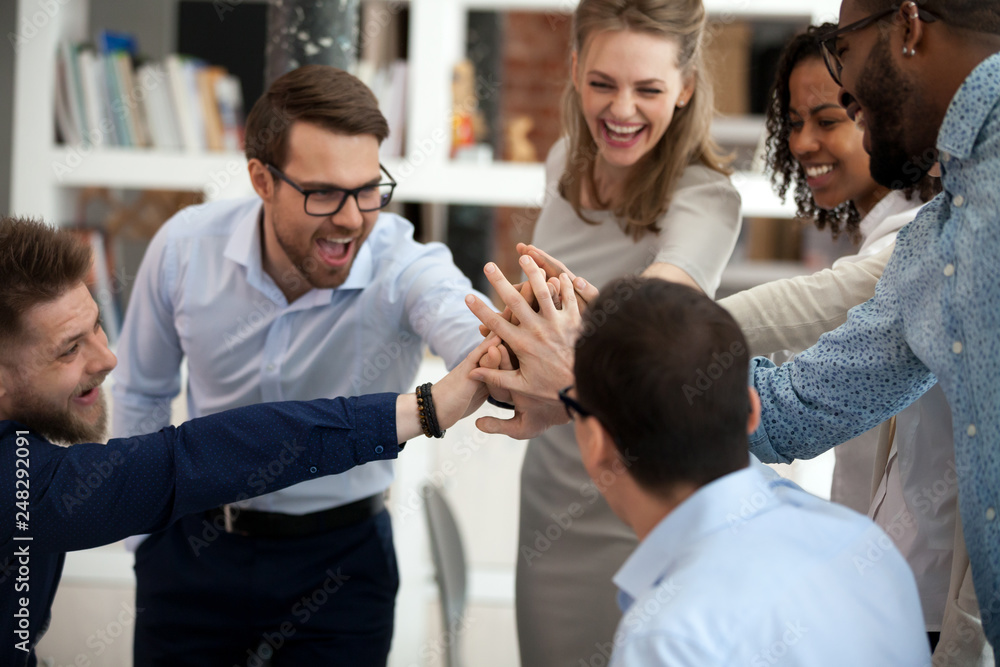 Excited motivated multi-ethnic team people give high five in office - obrazy, fototapety, plakaty 