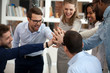 Excited motivated multi-ethnic team people give high five in office