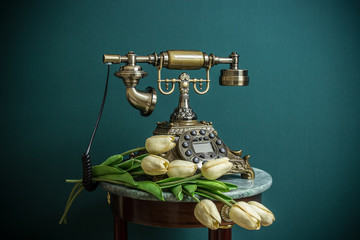 retro phone on a green background with white tulips