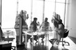 © alfa27 - Side view of blurred silhouettes of businessmen talking in conference room, view through the transparent glass wall