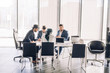© alfa27 - Business meeting between multiracial upper management board members in the new modern office conference room with panoramic windows and laptop.
