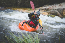 Close Up Image Of A White Water Kayak Paddler Riding White Water On A Mountain River
