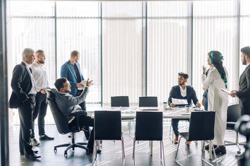 Wall Mural - Hot debates. Group interracial business partners disagree with company CEO dressed Arab, on contract terms, people have dispute , using lots of hand gestures, but staing positive meeting in office