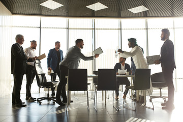 mixed race business partners arguing about bad contract. , investors having problrms with clients. p