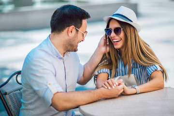 Wall Mural - Beautiful loving couple sitting in a cafe enjoying in coffee and conversation