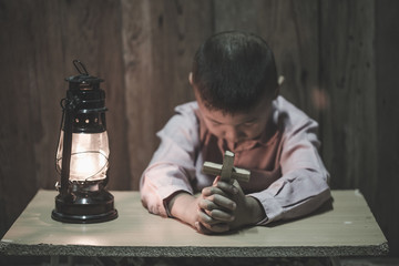 Wall Mural - Child praying, Little childs hands holding wooden cross.