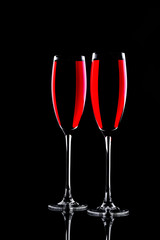 Two glasses with sparkling red wine, on a black background, close-up.