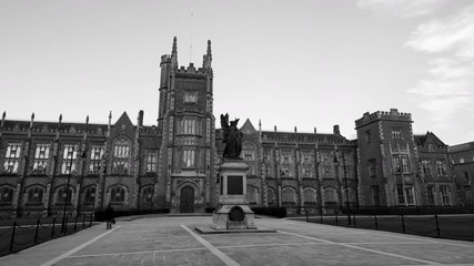 Wall Mural - Belfast, UK. The Lanyon Building, Queen's University Belfast, Northern Ireland, UK. Time-lapse in the evening with cloudless blue sky. Moving hyperlapse. Black and white