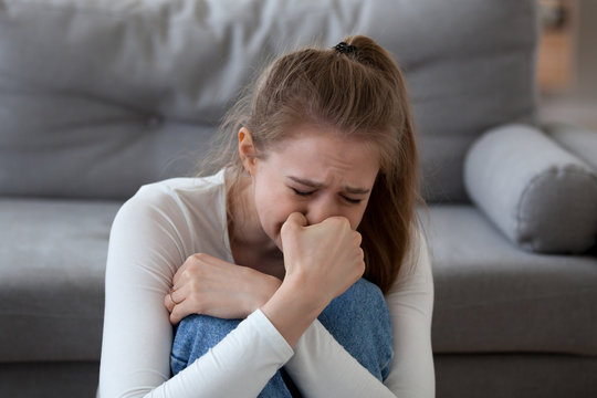 Desperate upset teen girl victim crying alone at home