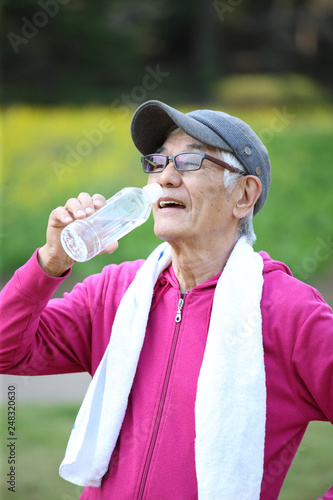屋外で運動の合間にペットボトルの水を飲む高齢者の男性 Stock 写真 Adobe Stock