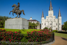 St. Louis Cathedral, Jackson Square, Louisiana, United States. Color Horizontal Image With Andrew Jackson Statue In Foreground With Red Flowers.