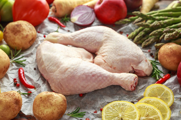 Wall Mural - Raw Chicken Legs on baking paper with variety of vegetables