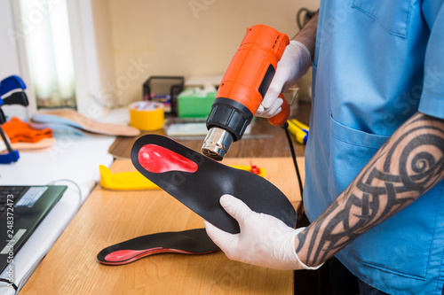 Closeup Hands Of Young Man With Tattoo In Workshop Dressed In Blue