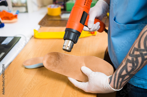 Closeup Hands Of Young Man With Tattoo In Workshop Dressed In Blue