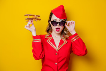 charming vintage stewardess wearing in red uniform with airplane