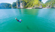 man jumping into water from a cruise boat on a sunny day in Ha Long bay, UNESCO world heritage site, Vietnam - freedom and adventure holiday concept