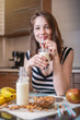 © Artem - Woman drinking organic almond milk holding a glass in her hand in the kitchen. Diet healthy vegetarian product