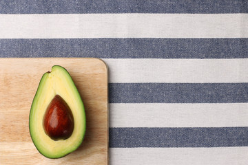 Wall Mural - half avocado on wooden and textile background