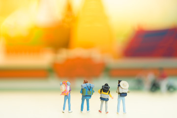 Miniature people: Group of backpacker standing in front of stunning beautiful temple in Thailand using as background or tourist business concept.