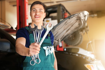 Sticker - Young auto mechanic with tools near car in service center