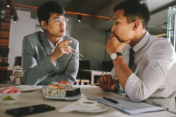 Business professionals discussing working over a lunch at restau