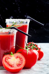 Tomato juice garnished with a rosemary branch and fresh ripe red cherry tomatoes