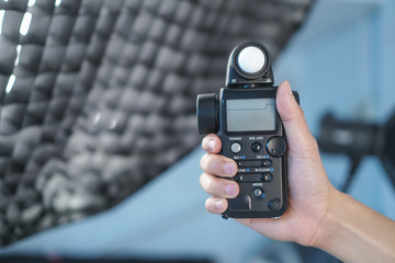 Hand held light meter isolated in studio lights