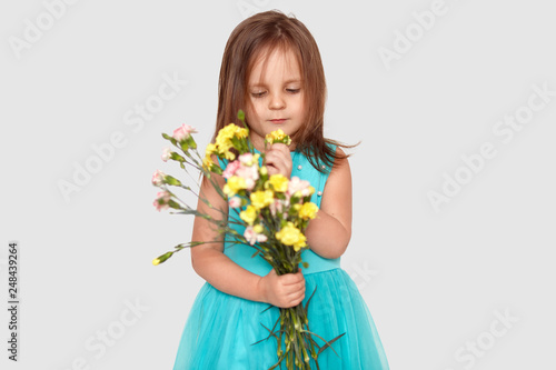 Pleasant Looking Kid With Dark Straight Hair Focused Down On
