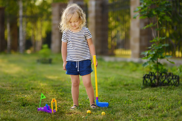 little girl playing mini golf in spring park. frustrated child, failure, missed.