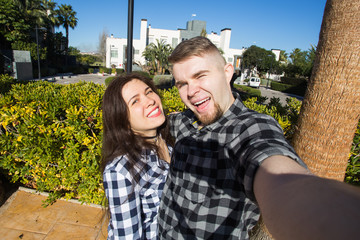 Wall Mural - Travel, vacation, summer and holiday concept - Nice couple taking selfie on hotel court