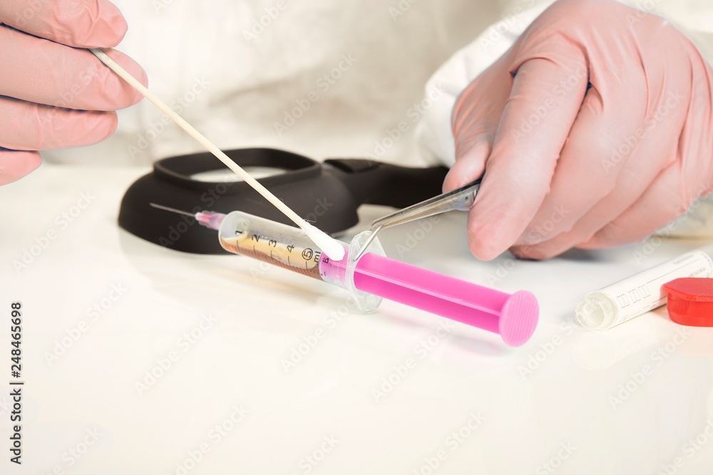 Foto de Stock Unpacking of evidence - syringe with narcotics from place ...