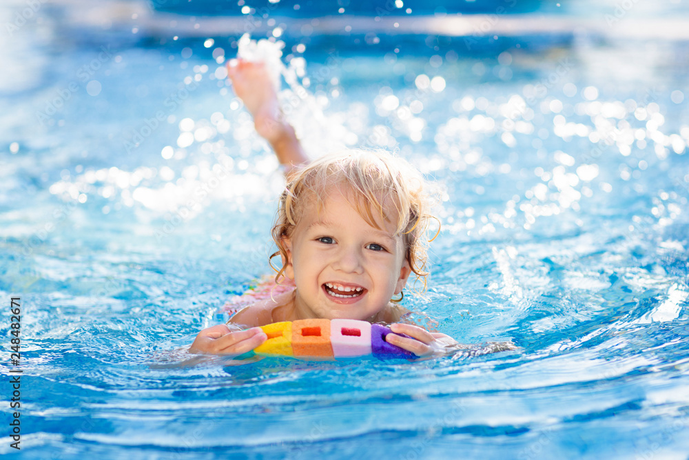 Child learning to swim. Kids in swimming pool. - obrazy, fototapety, plakaty 