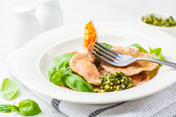 Wall Mural - Pumpkin ravioli with pesto sauce in a white plate.