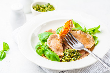 Wall Mural - Pumpkin ravioli with pesto sauce in a white plate.