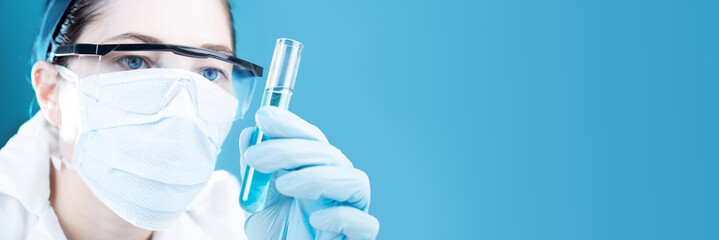 Wall Mural - chemist holding a test tube on blue background