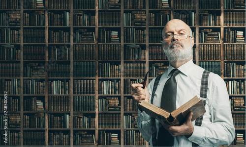 Fotografía Academic professor in the library holding a book