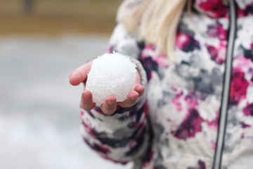 A girl holding a snow ball in her hand