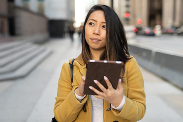 Poster - Young Asian woman in city walking using tablet computer