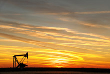 Pump Jack In The Oil Field At Sunset