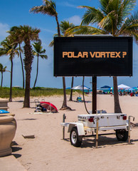 Wall Mural - Polar Vortex? message on an electric digital sign on a warm sunny beach